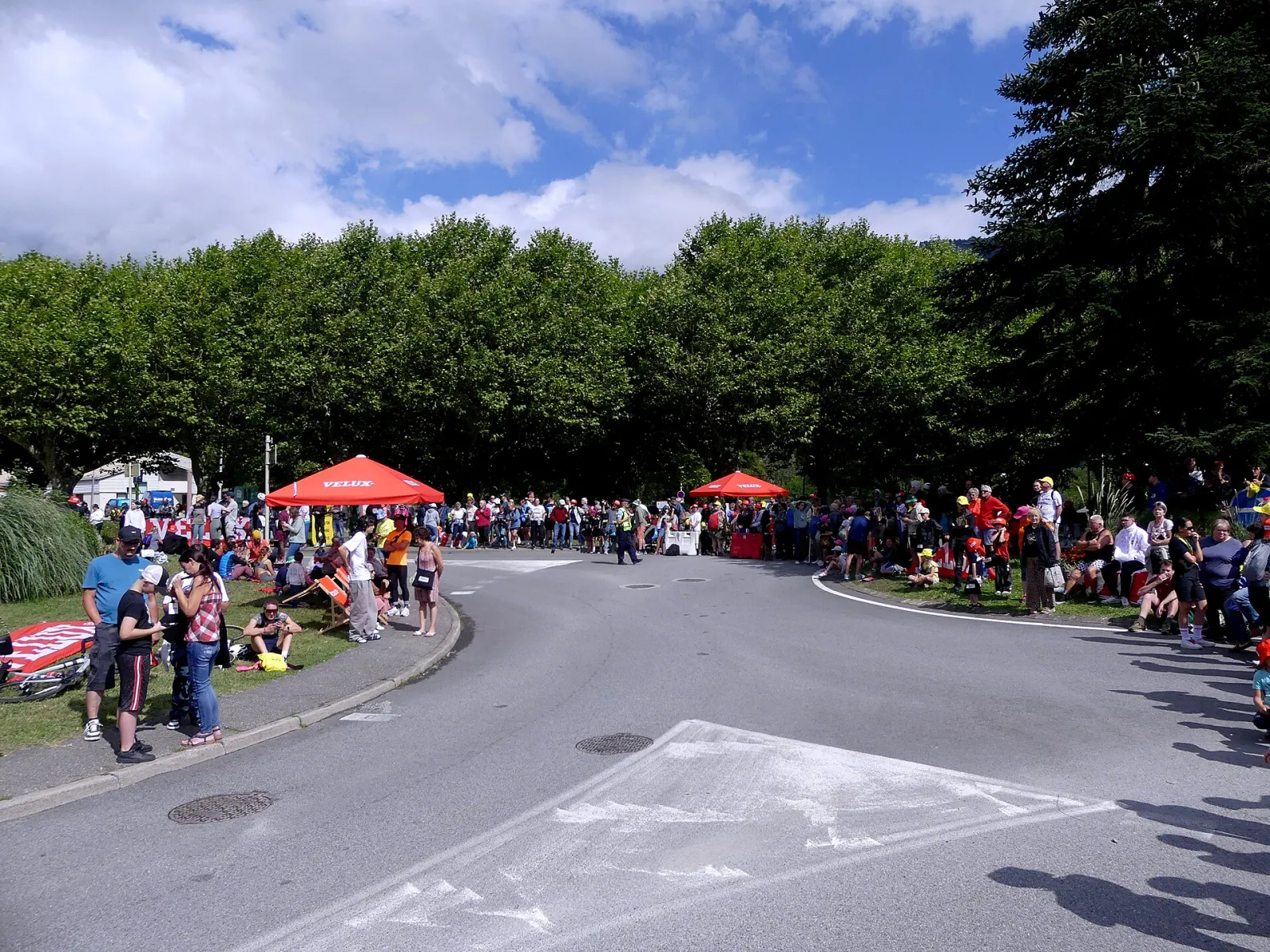 Spectateurs installés de part et d'autre d'un carrefour, attendant le passage du Tour de France Femmes 2025